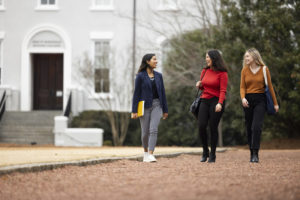(L-R) Foundation fellow student Priyanka Parikh talks with her friends foundation fellow Mariah Cady and honors student Sophie Murtey along side Herty Field with Moore Hall in the background.